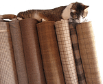 Cat on rug hooking wool bolts