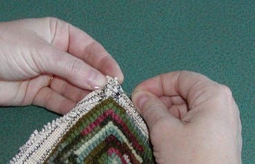 The first step in preparing the edge of a hooked rug