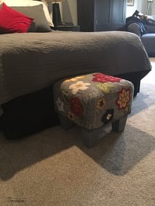 rug hooked footstool in place to help elderly dog get onto the bed