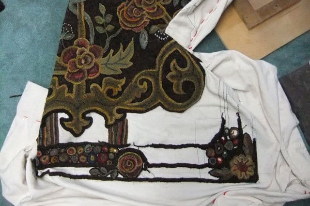 Working on the border of a room sized hooked rug